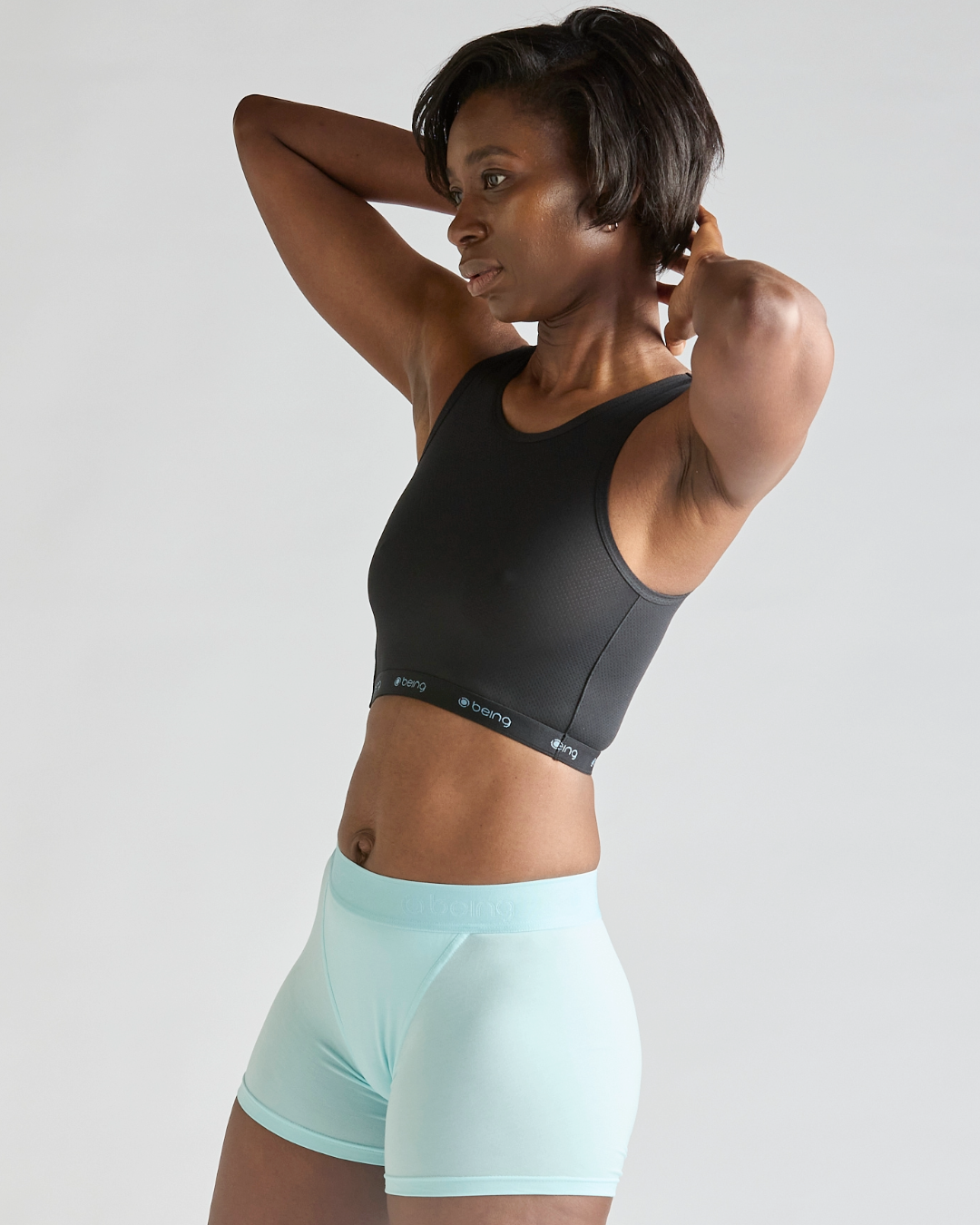 Person wearing the Being Wear Smoothing Crop, a lightweight chest-support top with adjustable side fastenings.